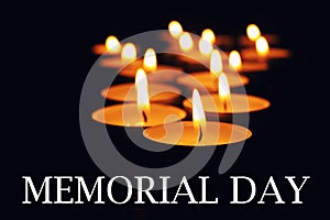 Memorial day. Wax candles burning on black background photo