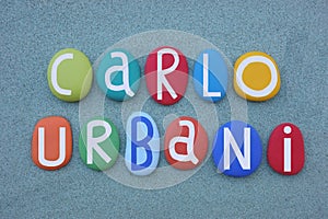 Memorial multi colored stone letters composition of Doctor Carlo Urbani over green sand