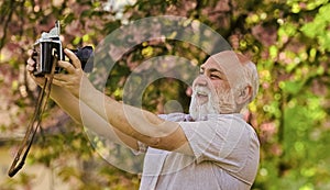Memories in snap. Everyone photogenic. Senior man taking selfie photo vintage camera. Retro equipment for taking photo