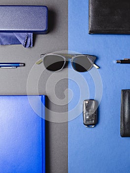 Men accessories, sunglasses, agenda, car key, pen over two colors creative background