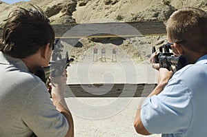 Men Aiming Rifles At Firing Range photo