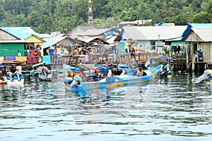 Men on anchored boat by fishermen village in Manokwari