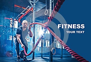 Men with battle rope battle ropes exercise in the fitness gym.