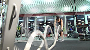 Men with battle rope in functional training fitness gym. young cute model.