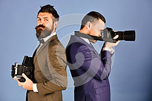 Men with beards hold photo cameras on blue background