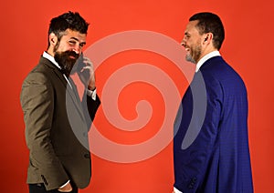 Men with beards stand face to face on red background. photo