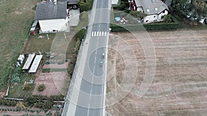 Men on bikes riding in Doussard commune, France, Alps mountains. Drone view of tourists cycling across fields