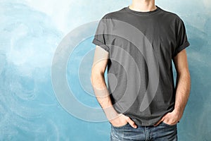 Men in blank grey t-shirt against blue background