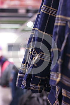 Men`s blue plaid shirts on hangers in the store