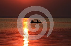 Men in a boat at the sunset