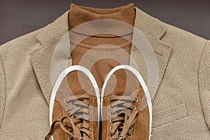 Men brown suede sneakers combined with light beige blazer and sweater.