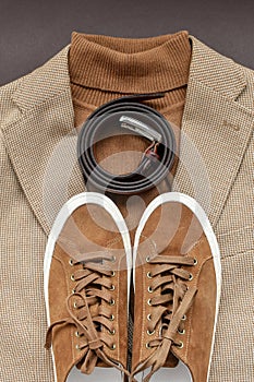 Men brown suede sneakers combined with light beige blazer, sweater and belt.