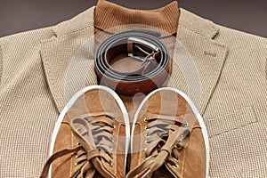 Men brown suede sneakers combined with light beige blazer, sweater and belt.