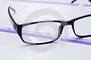 Men business glasses on the table with calendar