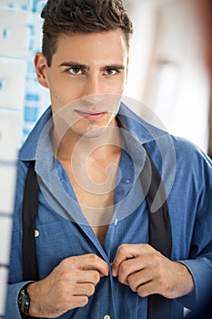 Men buttoning his shirt