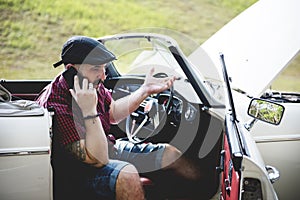 Men Calling Mechanic for Broke Down Car on Street Side with Open