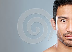 Men can have sensitive skin, too. a handsome young man posing against a grey background.