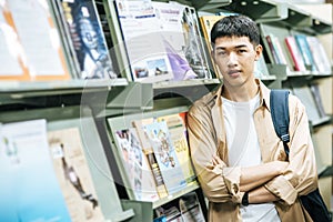 Men carrying a backpack and searching for books in the library