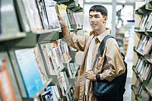 Men carrying a backpack and searching for books in the library