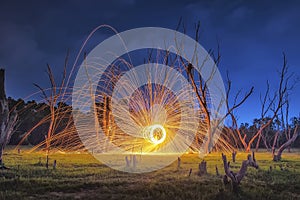 Men cast field Fire steelwool in the sunrise time.