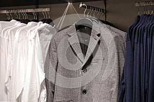 Men casual clothes in store, trendy jackets, shirts, cardigans on hangers
