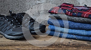 Men casual outfit. Men& x27;s shoes, clothing and accessories on wooden background - sweater, jeans, sneakers. Top view. Flat lay