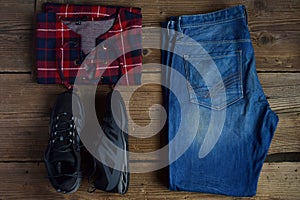 Men casual outfit. Men& x27;s shoes, clothing and accessories on wooden background - sweater, jeans, sneakers. Top view. Flat lay