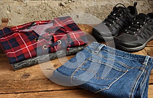 Men casual outfit. Men& x27;s shoes, clothing and accessories on wooden background - sweater, jeans, sneakers. Top view. Flat lay