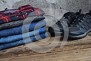 Men casual outfit. Men& x27;s shoes, clothing and accessories on wooden background - sweater, jeans, sneakers. Top view. Flat lay