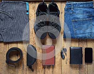 Men casual outfits. Men shoes, clothing and accessories on wooden background - grey t-shirt, blue jeans, sneakers with eyeglass