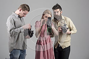 Men in checkered clothes, retro style. Company of busy photographers with old cameras, filming, working. Men and woman