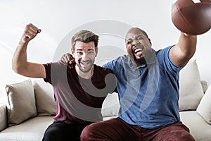 Men cheering sport together at home