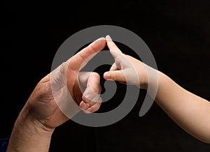 Men and child's fingers touching