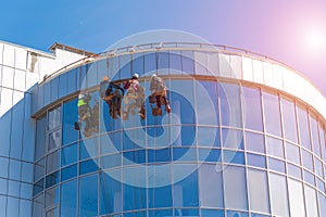 Men cleaning glass building. high-rise, industrial alpinism