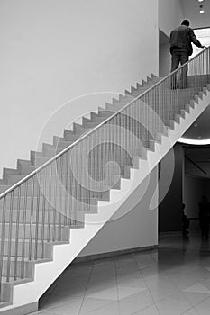 Men climbing up stairs in library (b/w)