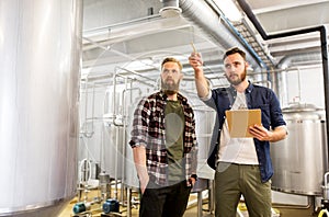 Men with clipboard at craft brewery or beer plant