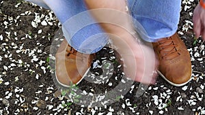 Men commits an outdoor walk and stopped to tie his shoelaces on sneakers.