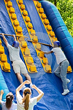 Men competing in climbing on inflatable slide