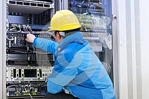 Men connect the network cable to the switch in the engine room