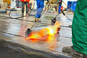 Men crout roof with hot tar photo