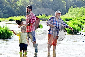 Men day. Family bonding. Fly fisherman using fly fishing rod in river. Fly fishing for trout. Grandfather and grandchild