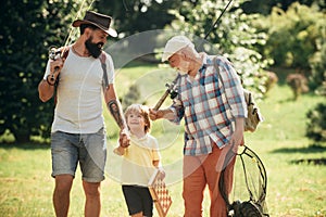 Men day. Happy grandfather, father and grandson with fishing rods. Anglers.