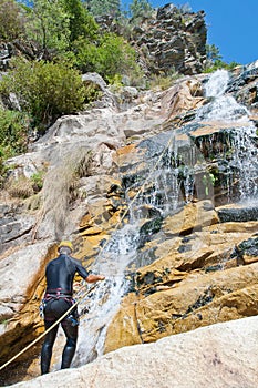 Men descending waterfall