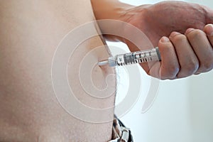 Men diabetes patient using insulin injection pen in abdomen area on white background isolate