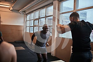 Men doing box jumps together during a gym workout