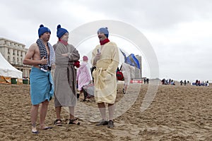 Men in dressing gowns on the beach