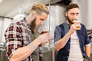 Men drinking and testing craft beer at brewery