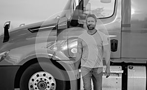 Men driver near lorry truck. Man owner truck driver in t-shirt near truck. Handsome middle aged man trucker trucking