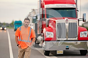 Men driver near lorry truck. Truck driver in safety vest near truck. Hispanic man trucker trucking owner. Transportation