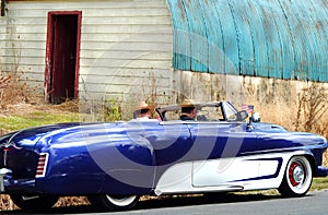 Men driving 1952 fifties Dodge custom two door convertible on country drive